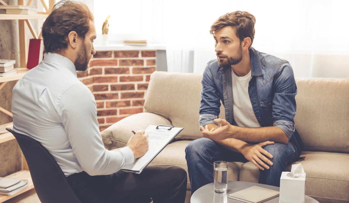 Counselor writing on a notebook while treating a patient