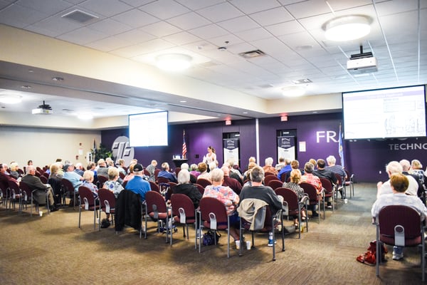 Nikki Buckelew presents to a large crowd at a free series on senior living.