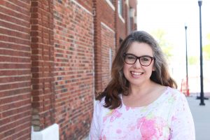 woman standing next to brick wall