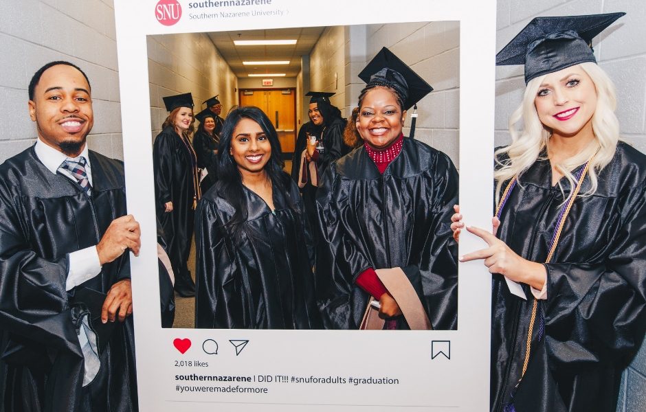 Classmates standing together in graduation regalia