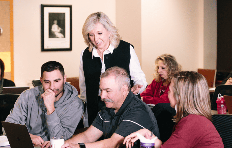 Instructor working with adult students in class