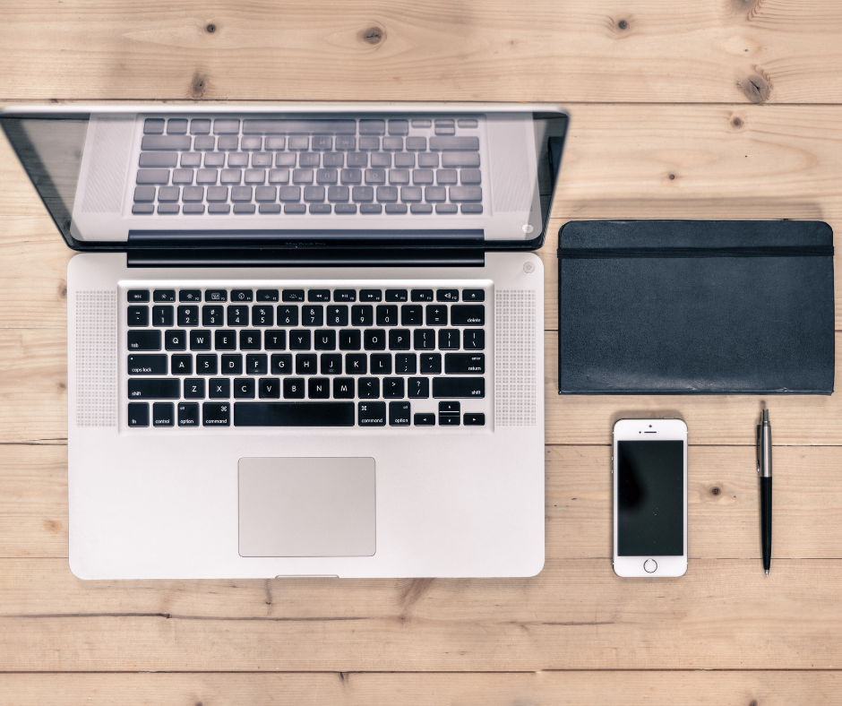 laptop, phone and planner on table