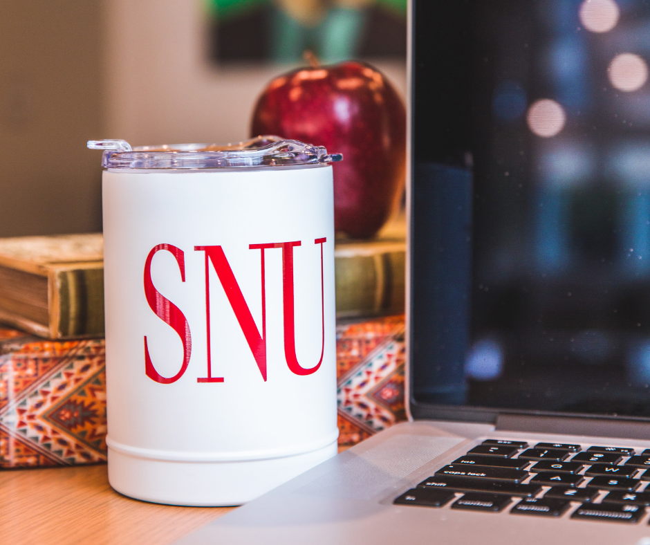 SNU mug next to laptop computer