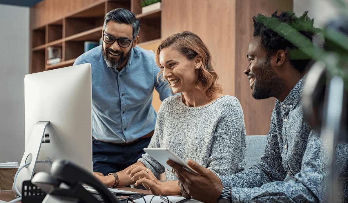 3 professionals looking at a computer